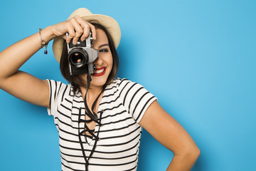 Wall Mural - Fashion young girl makes the photo with old camera. Blue backgro