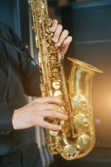 musical instrument saxophone close-up. hands on a musical instrument. young guy playing jazz.