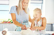 © Flamingo Images - Excited little girl helping her mother make pastry