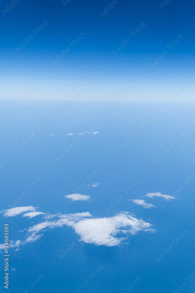 Piękny widok z samolotu na horyzont - błękitne niebo nad chmurami i ocean - obrazy, fototapety, plakaty 
