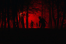 Bloodthirsty Zombies Attacking. Hungry Zombies In The Woods. Silhouettes Of Scary Zombies Walking In The Forest At Night