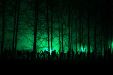 Crowd Of Hungry Zombies In The Woods. Silhouettes Of Scary Zombies Walking In The Forest At Night. Green Acid Variant