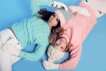 Wall Mural - fashion studio photo of beautiful girls with curly hair  in warm cozy winter clothes 