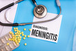 Meningitis word written on medical blue folder