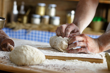 Wall Mural - Close up of male baker hands kneading the dough with flour powder.
