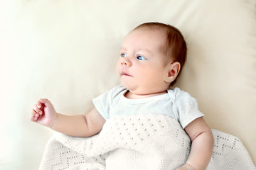 Wall Mural - Portrait of cute baby lying on bed