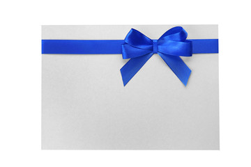 Wall Mural - Blue satin ribbon and card on light background