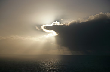 Wall Mural - clouds obscuring sun over ocean