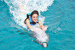 young woman riding dolphin