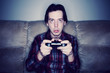 © ten03 - Man playing video games in a dark room