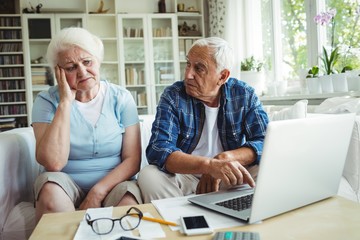 Wall Mural - Worried senior couple using laptop