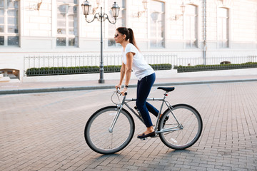 Poster - Side view portrait of a beautiful woman riding on bicycle