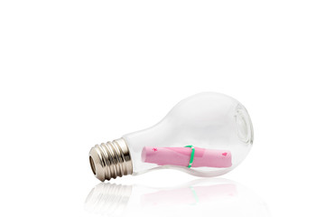 Light bulb with pink paper note inside isolated on white backgro