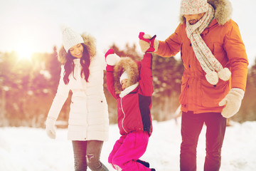 Wall Mural - happy family in winter clothes walking outdoors