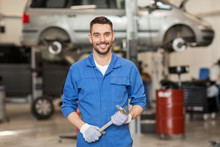 Auto Mechanic Or Smith With Wrench At Car Workshop