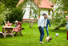 Friends Playing Football With Dog At Summer Garden