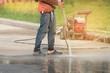 High pressure cleaning.Worker cleaning driveway with high pressure washer