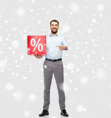 Wall Mural - smiling man with red percentage sign over snow