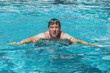 © travelview - handsome man enjoys swimming in the pool