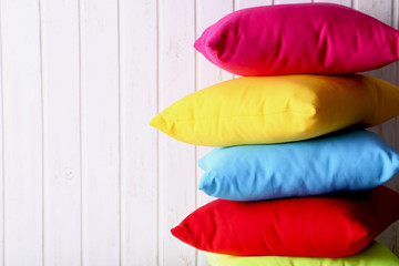 Colorful pillows on a white wall paneling background