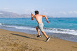Man runner sprinting on wet sand run at the beach