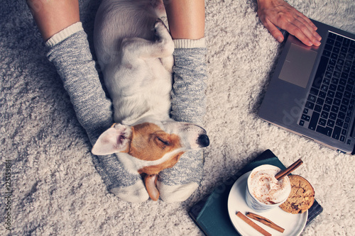 Woman in cozy home wear relaxing at home with sleeping dog Jack Tableau sur Toile