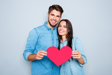 Young Happy Couple In Love Holding Red Paper Heart