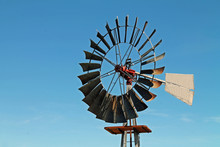 Metal Windmill Blade Against A Bright Blue Sky