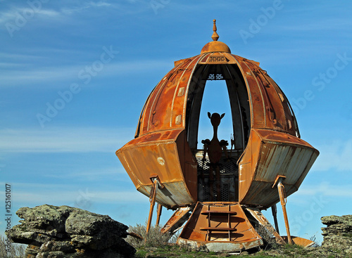 Rusty Metal UFO Against a Bright Blue Sky With Alien Silhouette плакат