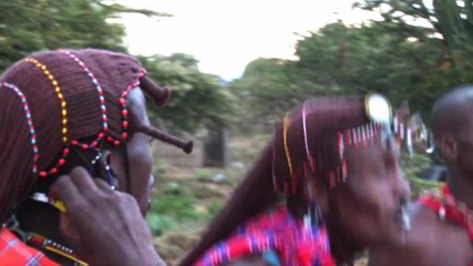 masai warriors in traditional clothing, play and sing in the twilight after sunset. it is evident du