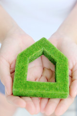 Fototapete - hand holding green house icon concept