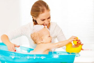 Wall Mural - Happy family mother bathes the baby in  bath