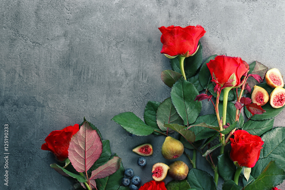 Beautiful red roses, figs and blueberries on grunge textured background