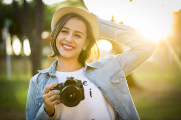 Young woman making photos with professional camera at summer gre