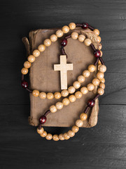 rosary and prayer book on a dark background