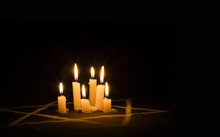 Six Burning Candles And The Star Of David Against A Black Background