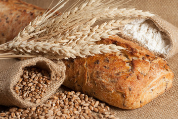 retro bread in rustic style background.Fresh traditional bread on wooden ground with flour in a sack.