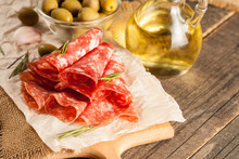 Italian Salami With Olives And Spices On Wooden Background