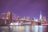 Fototapeta  - New York City skyline and Brooklyn Bridge at night with light and vintage toned filter effect