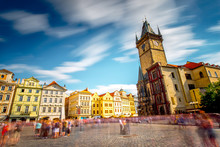 View On The Old Town Square With The Famous Clock Tower In Prague City. Long Exposure Image Technic With Blurred People And Clouds