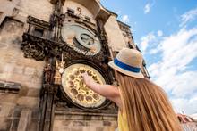 Female Tourist Pointing On The Famous Astronomical Clock In Prague