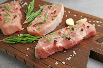 Poster - Steaks in marinade on wooden board, closeup