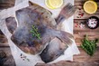 Raw flounder fish, flatfish on wooden table