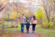 Family of three walks in the autumn park