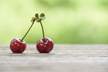 cherry fruit on wooden table over bokeh green background