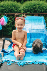 little girl on a chair by the pool