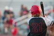 High school baseball player with long hair batting.