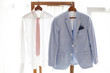 © hdesert - White shirt and gray suit of groom hanging on hanger