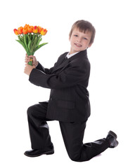 Wall Mural - side view of little boy in business suit giving flowers to someb