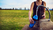 Female runner fills up water bottle outdoors